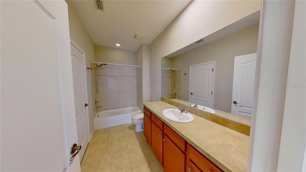 10620 Whittington Court Largo, FL 33771 - Photo 58 of 68 a bathroom with a granite countertop sink a mirror and a bathtub