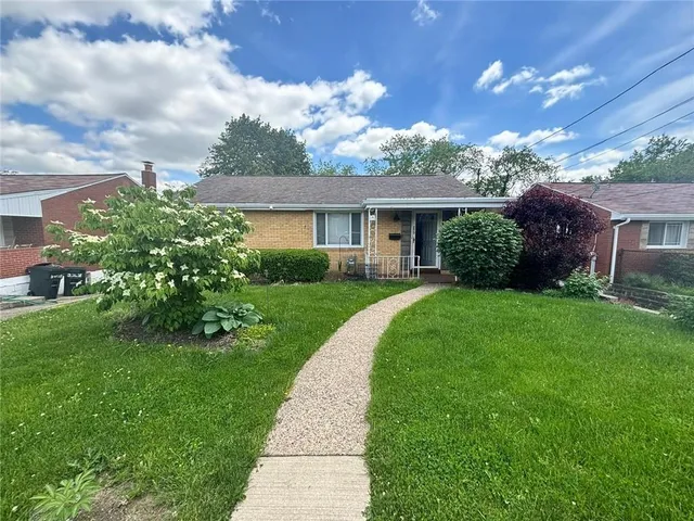 a front view of a house with a garden
