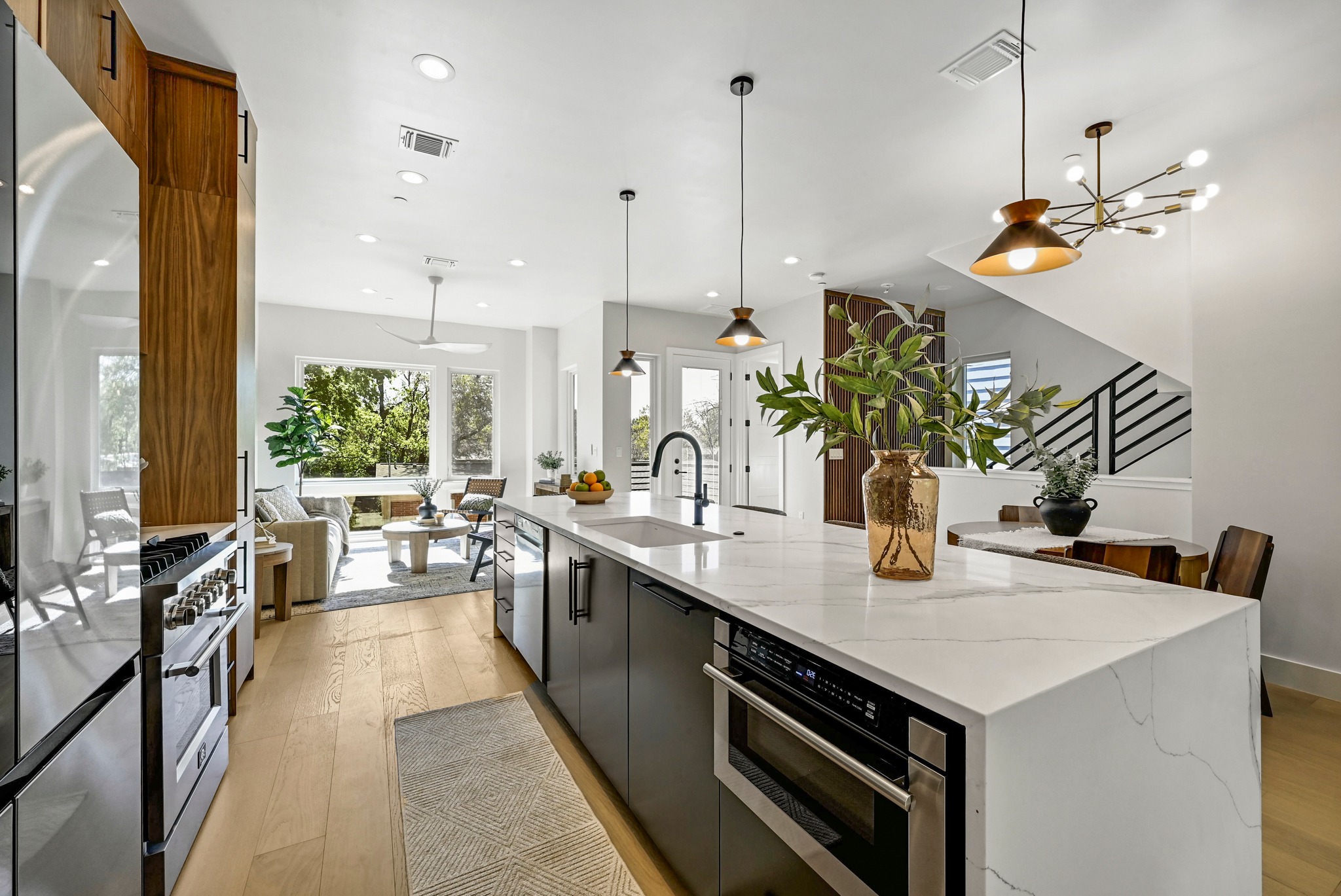 100 West Odell Street, Unit 2 Austin, TX 78752 - Photo 16 of 36 Kitchen featuring custom wood cabinets, quartz waterfall countertop with breakfast bar area, and high end stainless steel appliances.