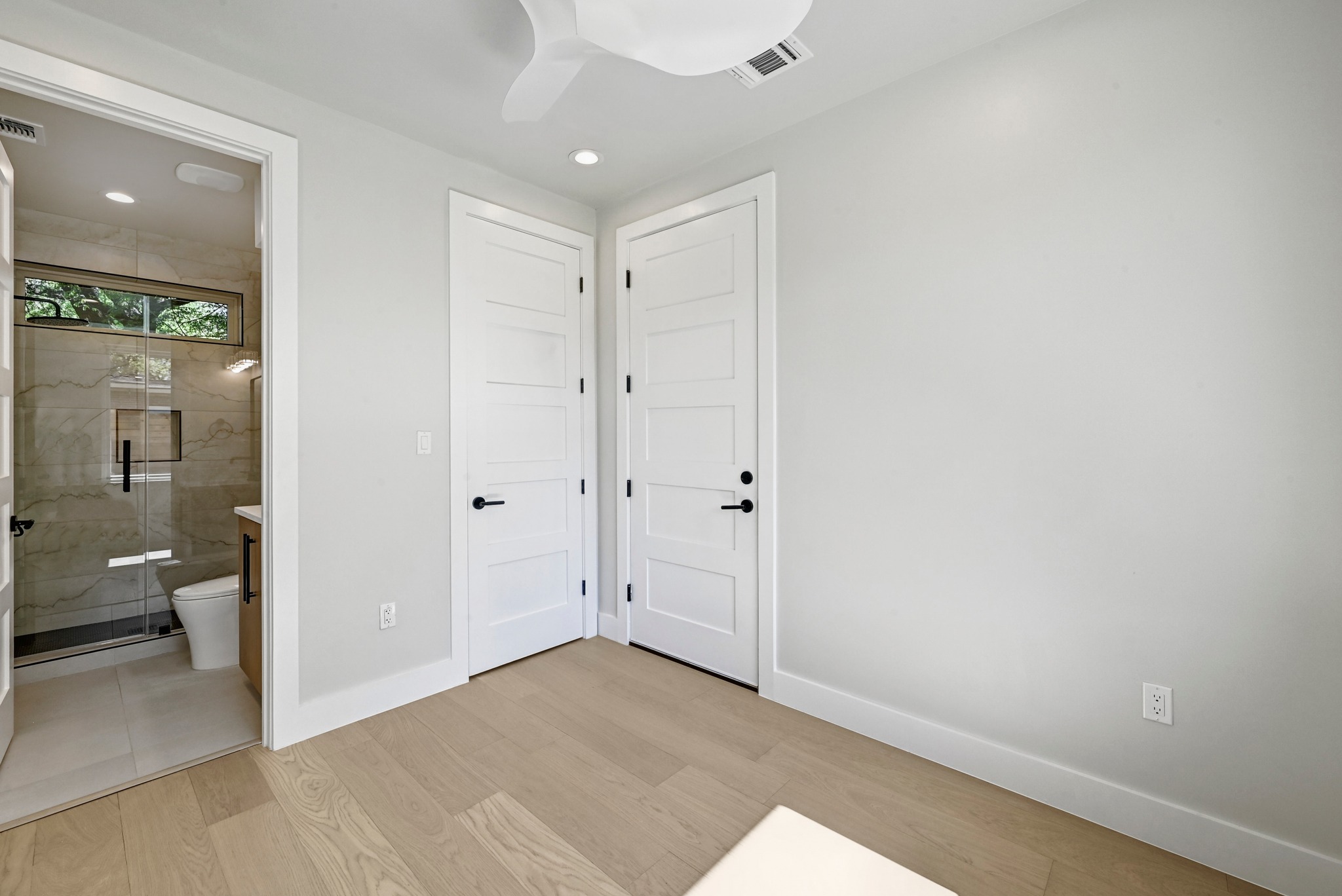 100 West Odell Street, Unit 2 Austin, TX 78752 - Photo 7 of 36 1st Floor Secondary Bedroom with connected bathroom, ceiling fan, and recessed lighting.