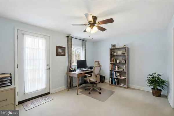 a view of a workspace with furniture and a window