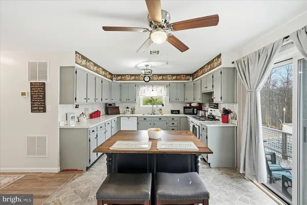 a room with stainless steel appliances kitchen island granite countertop a dining table and chairs