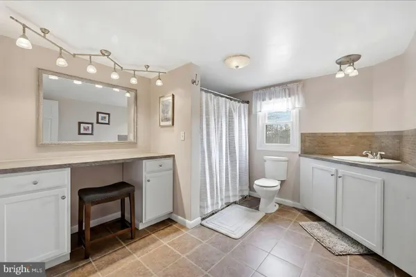 a bathroom with a toilet sink and mirror