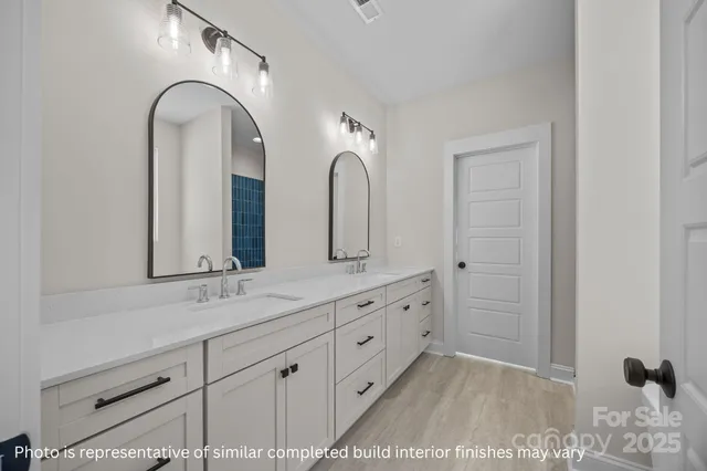 a bathroom with a double vanity sink and mirror