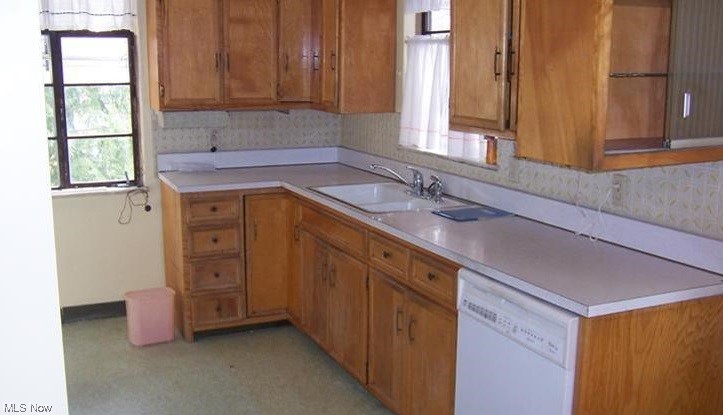 3185 Warren Road Cleveland, OH 44111 - Photo 15 of 19 Kitchen featuring white dishwasher, light countertops, and brown cabinets