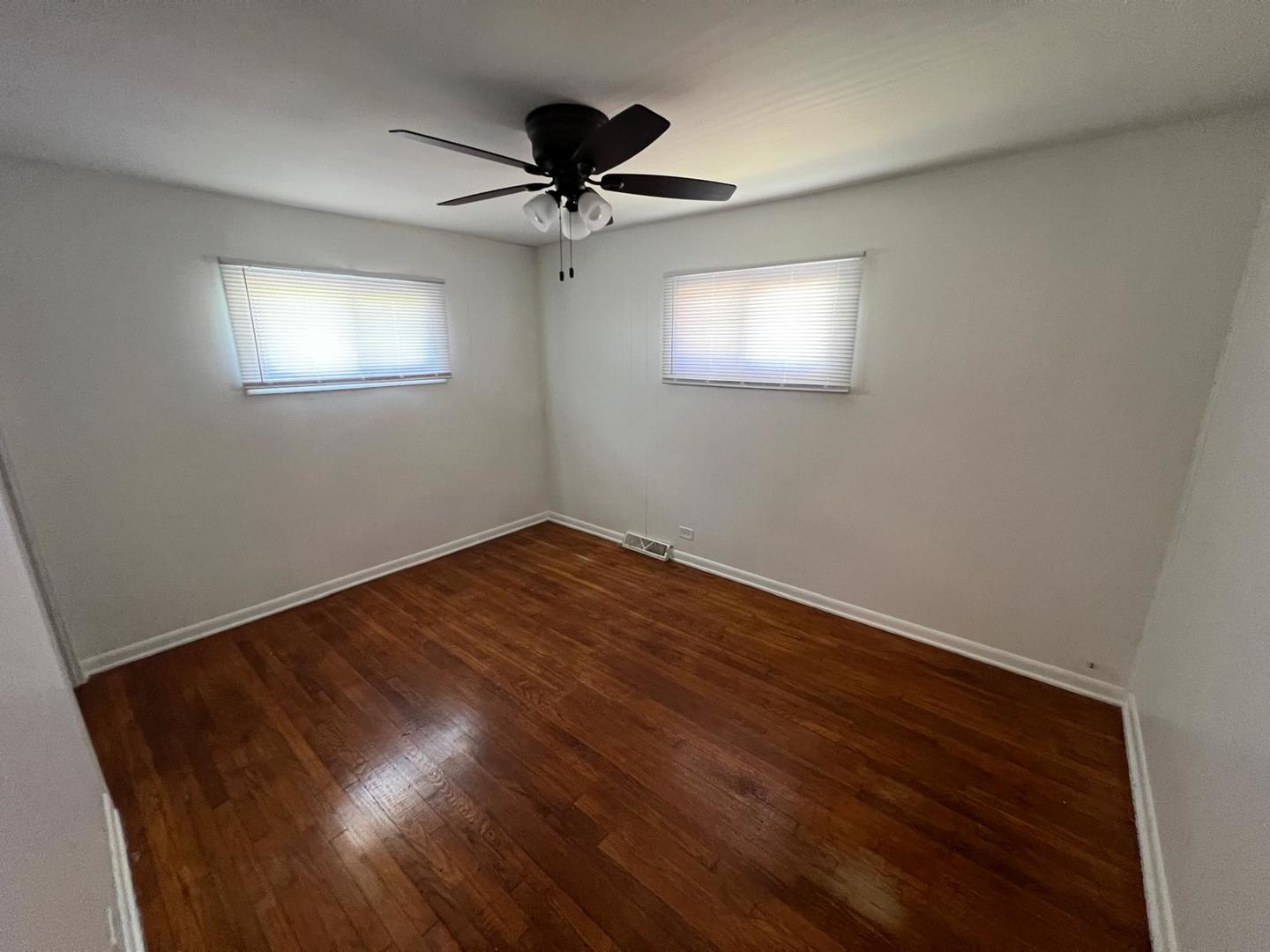 16442 Honore Avenue Markham, IL 60428 - Photo 6 of 16 a view of empty room with wooden floor and fan