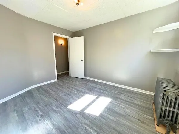 an empty room with wooden floor and closet