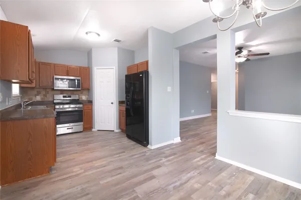 a kitchen with granite countertop a refrigerator and a stove top oven