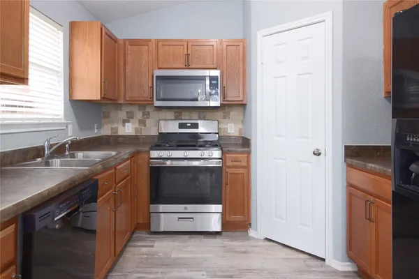 a kitchen with stainless steel appliances a stove a microwave a sink and cabinets