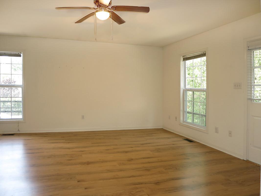 320 Davie Road Carrboro, NC 27510 - Photo 3 of 20 an empty room with wooden floor fan and windows