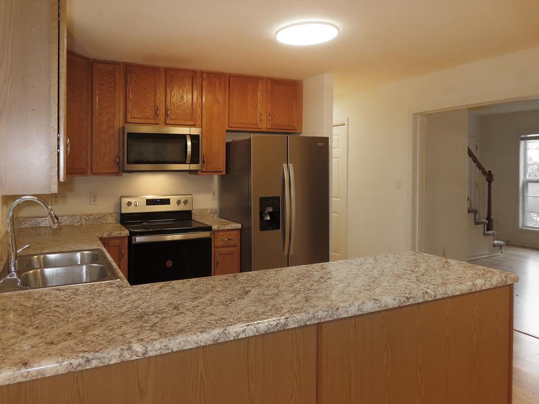 320 Davie Road Carrboro, NC 27510 - Photo 9 of 20 a kitchen with granite countertop wooden cabinets a refrigerator and a sink