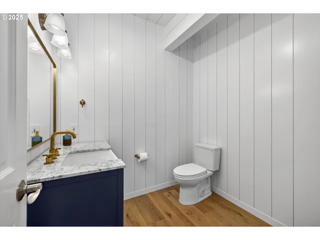 a view of a livingroom with wooden floor and a hallway