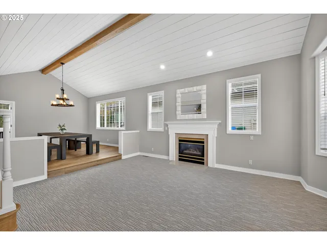 a view of an empty room with window and fireplace