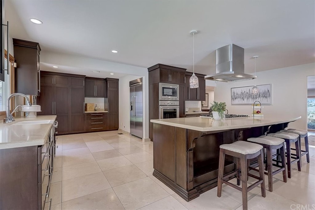 12392 Ranchview Drive Santa Ana, CA 92705 - Photo 14 of 72 a kitchen with kitchen island a sink counter and chairs