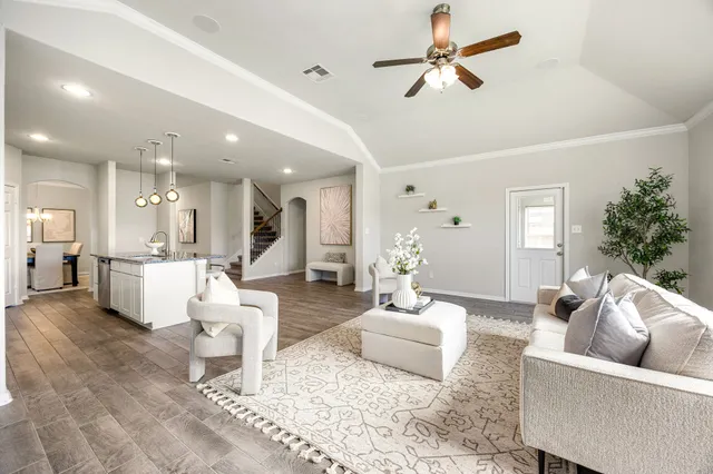 a living room with furniture and a view of kitchen