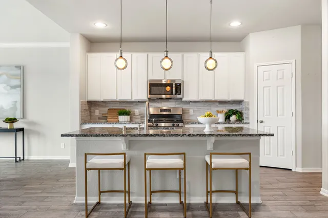 a kitchen with stainless steel appliances granite countertop a stove a sink and a refrigerator