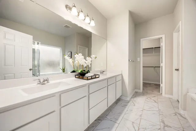 a spacious bathroom with a double vanity sink and a mirror