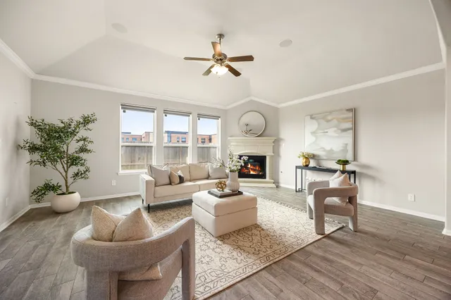 a living room with furniture a fireplace and a large window
