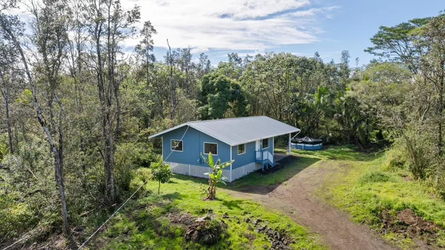 a view of a house with a big yard and large trees