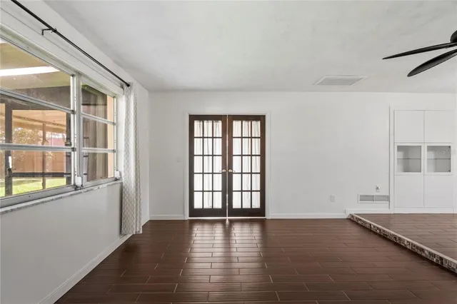 an empty room with wooden floor and windows