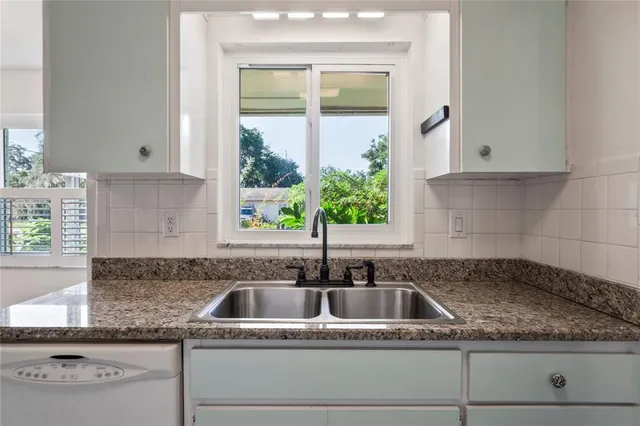 a kitchen with granite countertop a sink and a window