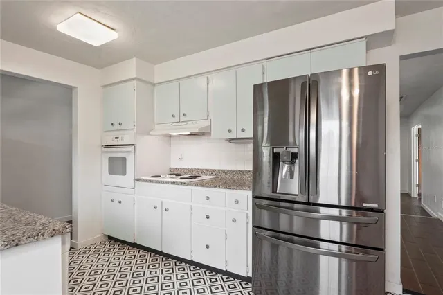 a kitchen with stainless steel appliances a refrigerator sink and cabinets