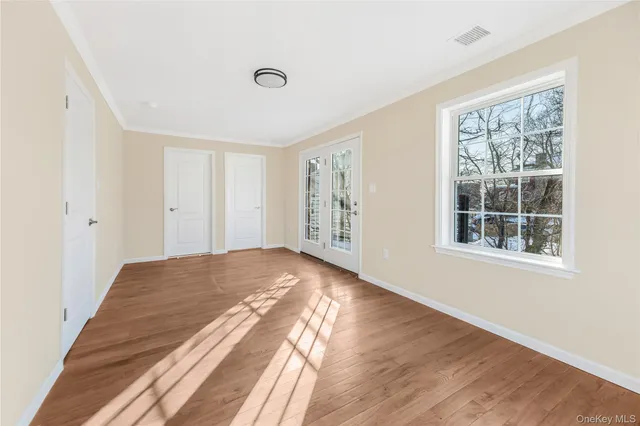 a view of empty room with wooden floor and fan