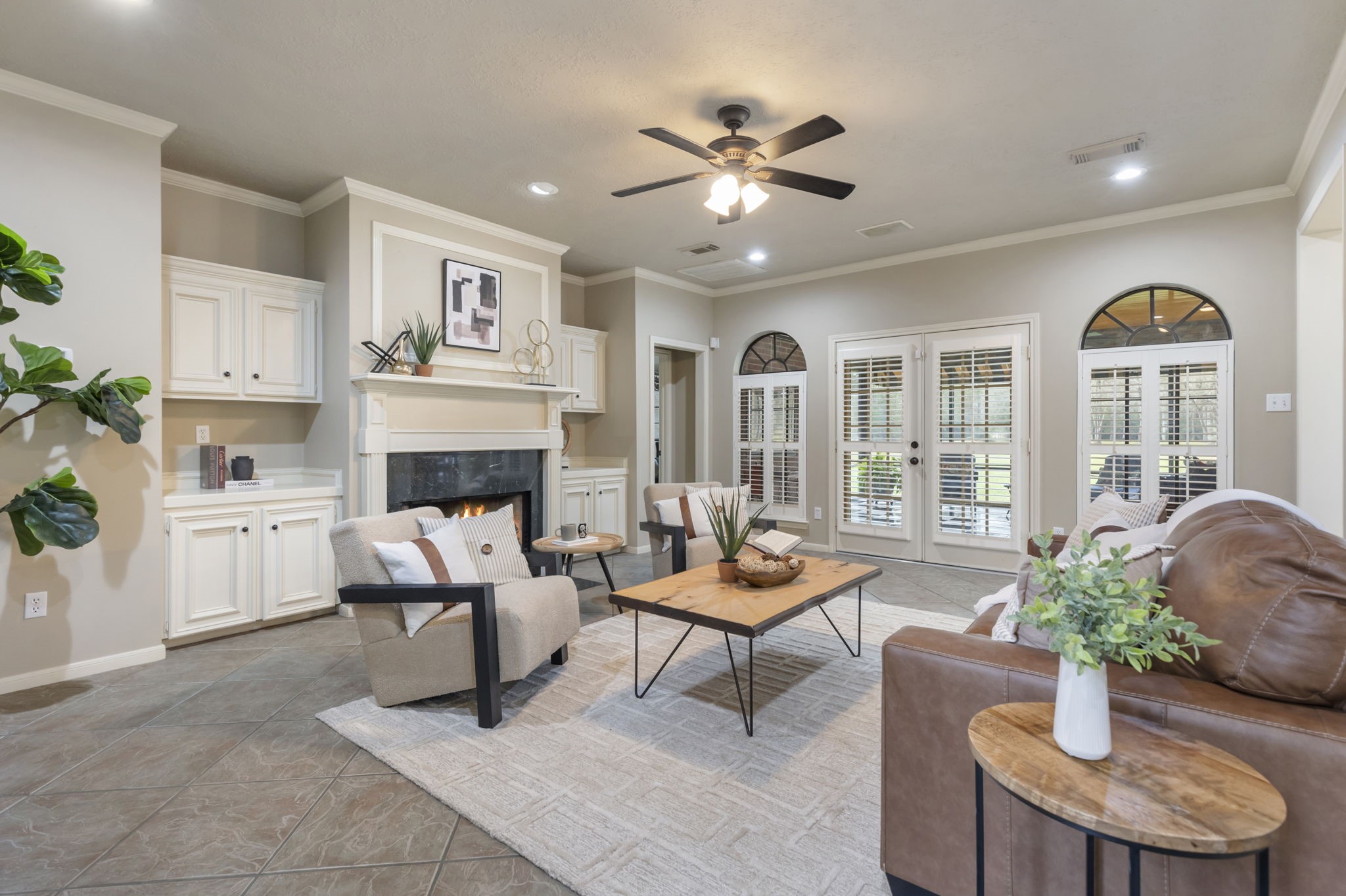39327 Lago Drive Magnolia, TX 77354 - Photo 14 of 39 The family room exudes warmth and charm, creating the perfect gathering space for loved ones. At its heart, a sleek, updated fireplace surround commands attention, blending contemporary sophistication with cozy appeal.