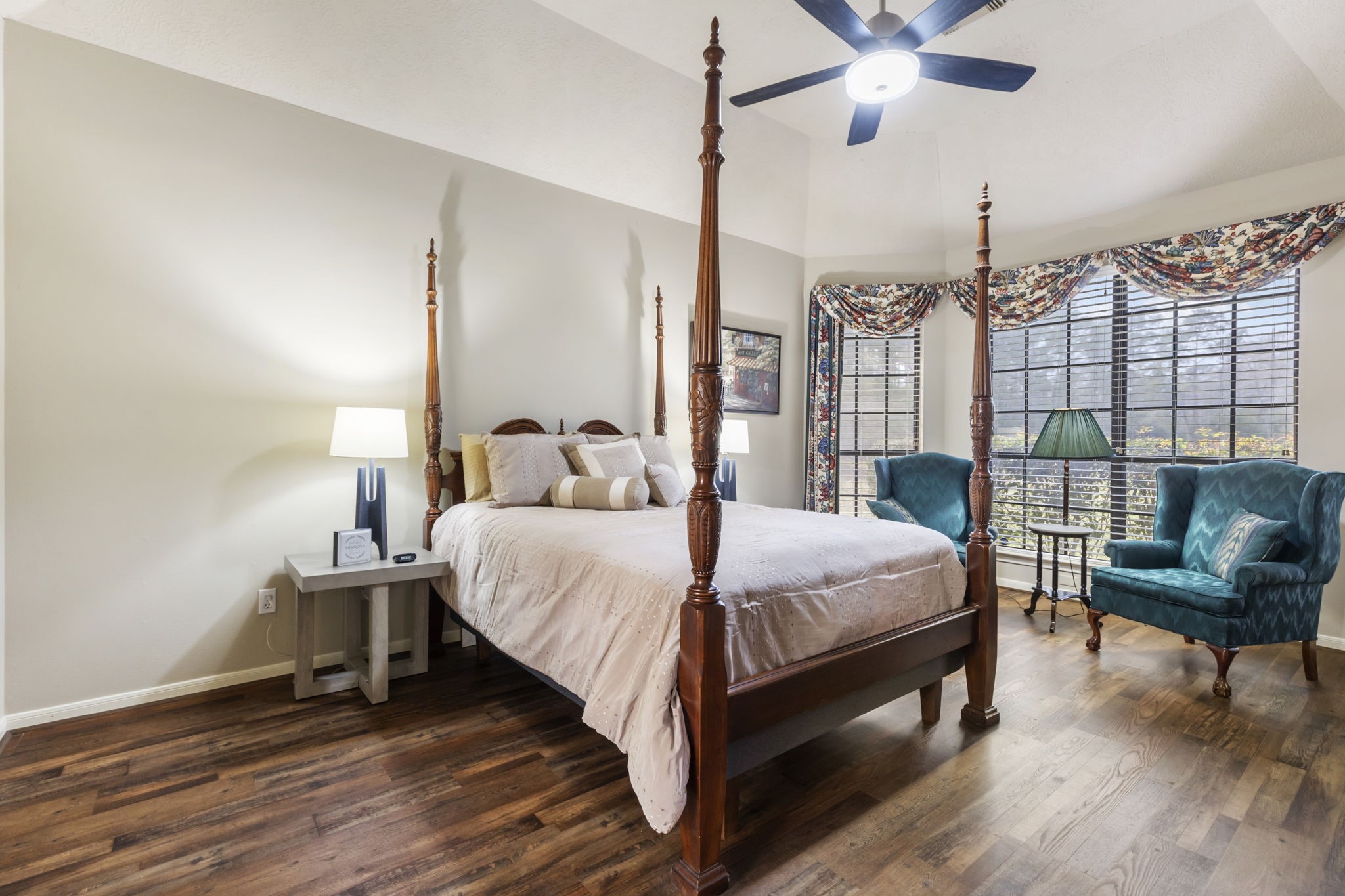 39327 Lago Drive Magnolia, TX 77354 - Photo 18 of 39 The first-floor primary suite is a true retreat, designed with comfort and relaxation in mind. Step into your private haven, where a cozy sitting area invites you to unwind with a good book or steaming coffee. Large windows frame tranquil views of the lush backyard, blending indoor and outdoor living. Whether it's the golden glow of sunrise or the stillness of twilight, this space offers the perfect backdrop to begin or end your day in tranquility.