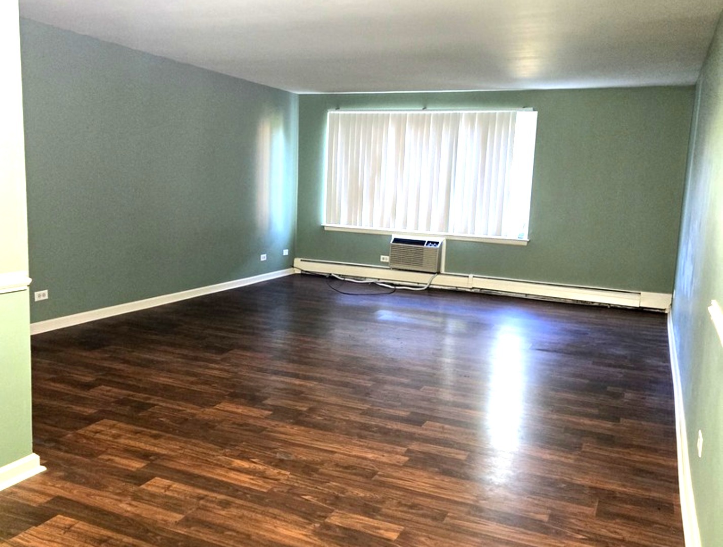1117 South Old Wilke Road, Unit 206 Arlington Heights, IL 60005 - Photo 3 of 9 an empty room with wooden floor and windows