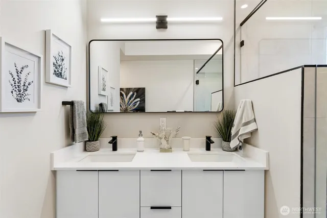 a bathroom with a double vanity sink a mirror and a shower