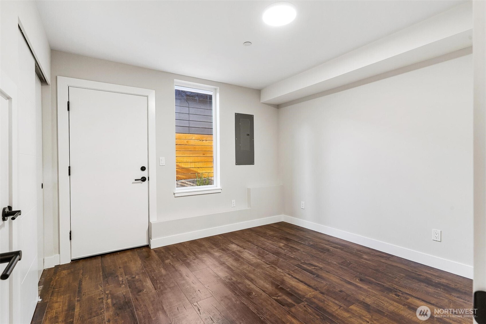 7146 47th Avenue Southwest Seattle, WA 98136 - Photo 23 of 34 a view of an empty room with wooden floor and a window
