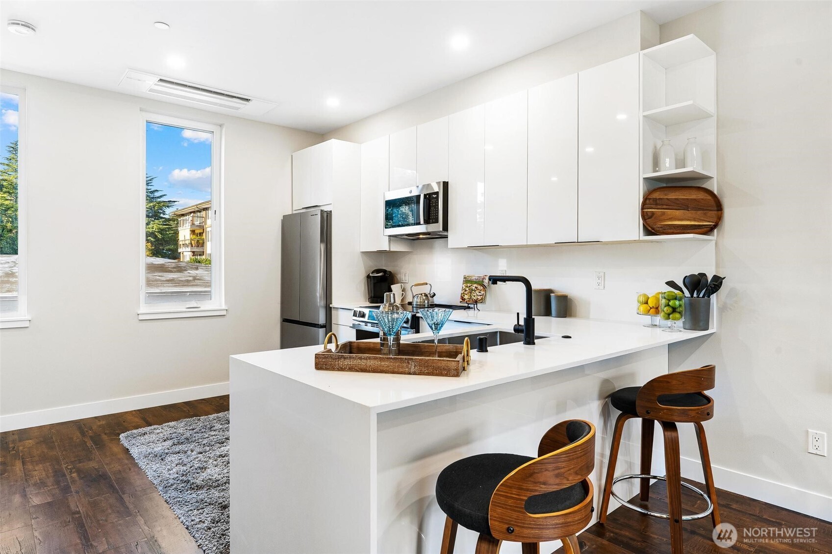 7146 47th Avenue Southwest Seattle, WA 98136 - Photo 8 of 34 a kitchen with a sink a stove and chairs