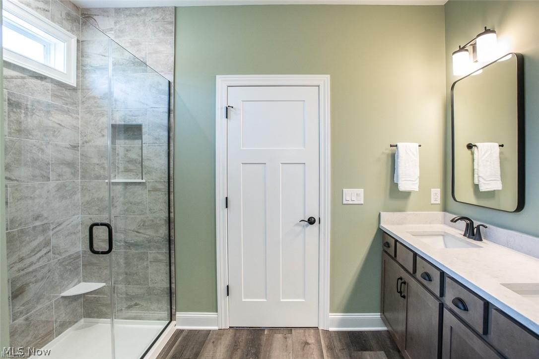 34286 Brookside Lane North Ridgeville, OH 44039 - Photo 25 of 50 Full bathroom with a stall shower, double vanity, and dark wood finished floors