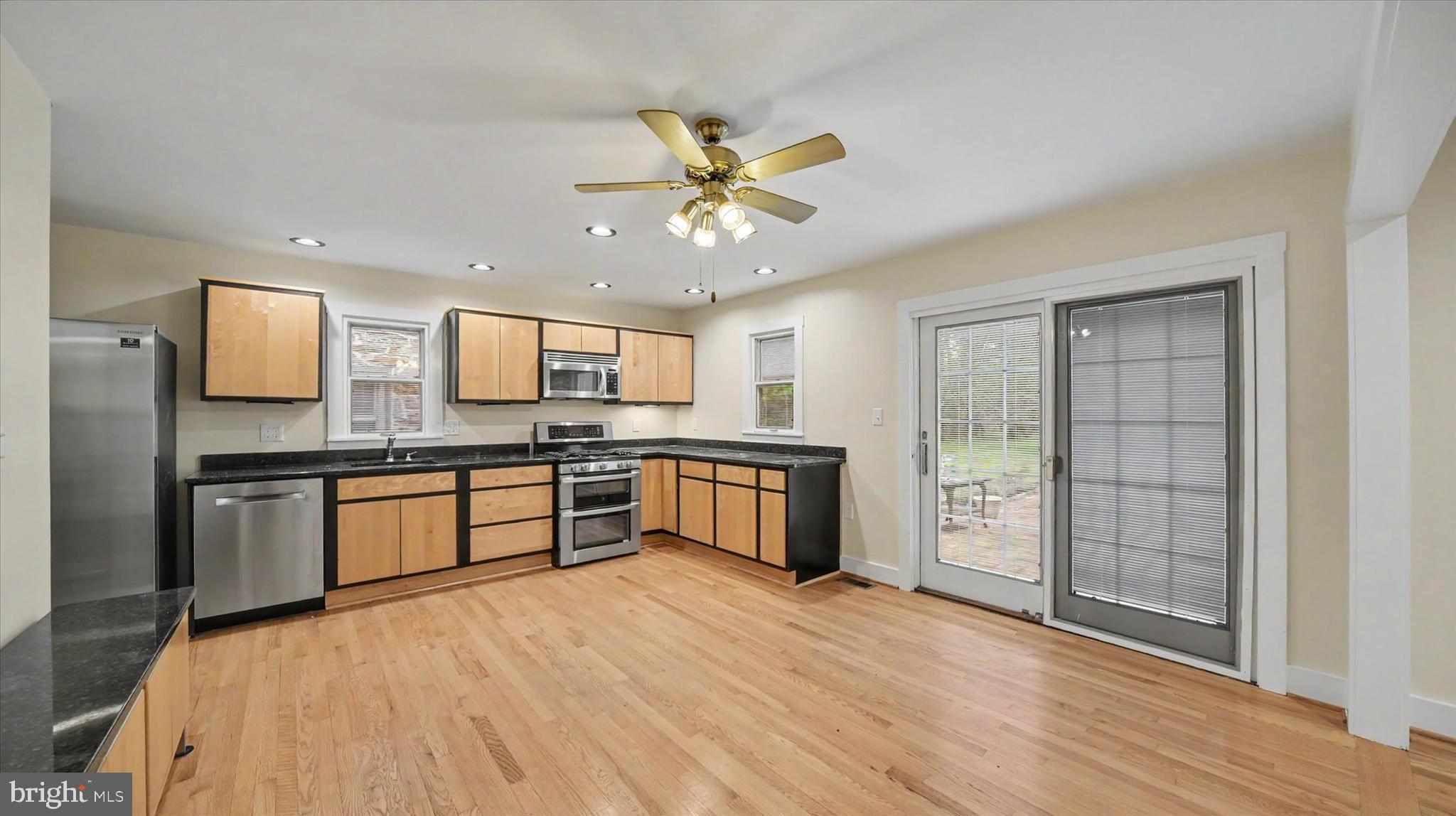4037 Grande View Drive Pylesville, MD 21132 - Photo 16 of 74 a large kitchen with stainless steel appliances granite countertop a refrigerator a sink dishwasher a oven with white cabinets and wooden floor