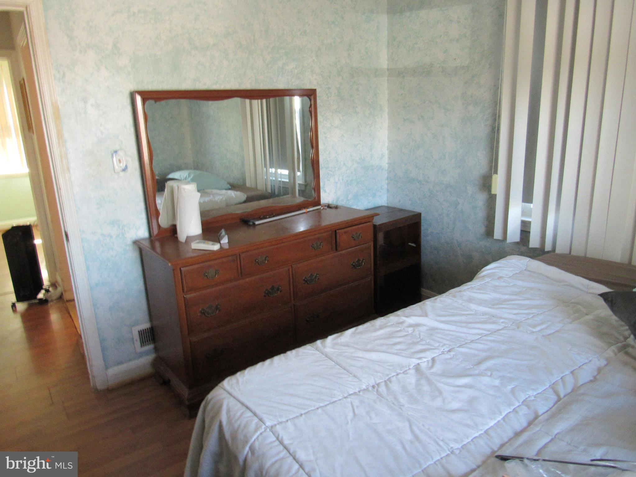 6301 Fieldvale Road Baltimore, MD 21237 - Photo 10 of 28 a bedroom with a bed and mirror with wooden floor