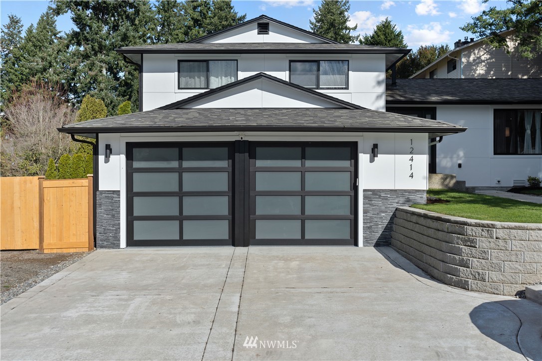 12414 Southeast 100th Street Renton, WA 98056 - Photo 5 of 40 a front view of a house with a yard and garage