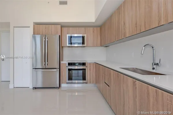 a kitchen with stainless steel appliances a refrigerator sink and cabinets