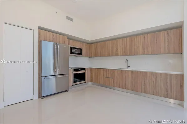 a kitchen with cabinets and stainless steel appliances