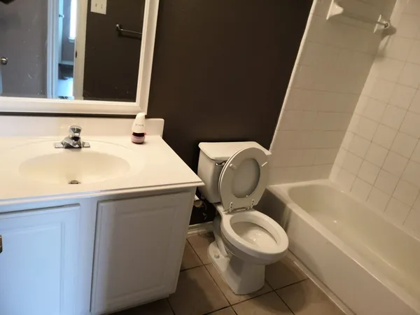 a white toilet sitting next to a bathroom sink