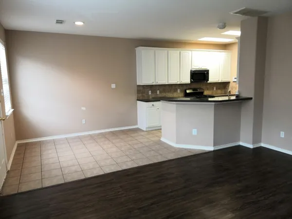a kitchen with granite countertop a stove and a wooden floor