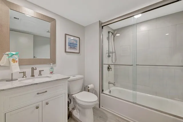a bathroom with a granite countertop sink toilet and shower
