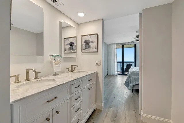 a en suite bathroom with a granite countertop double vanity sink a mirror and a shower