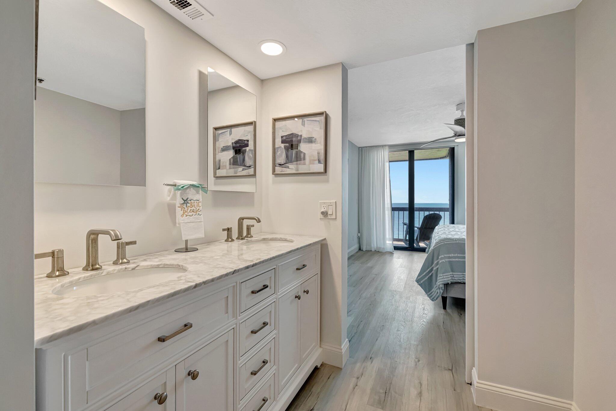 3100 North Hwy A1A, Unit 1102 Hutchinson Island, FL 34949 - Photo 23 of 55 a en suite bathroom with a granite countertop double vanity sink a mirror and a shower