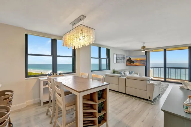a view of a dining room with furniture a chandelier and a window