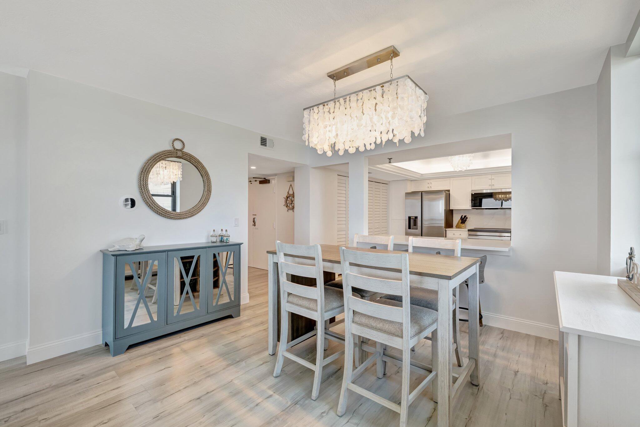 3100 North Hwy A1A, Unit 1102 Hutchinson Island, FL 34949 - Photo 6 of 55 a view of a dining room with furniture and a chandelier
