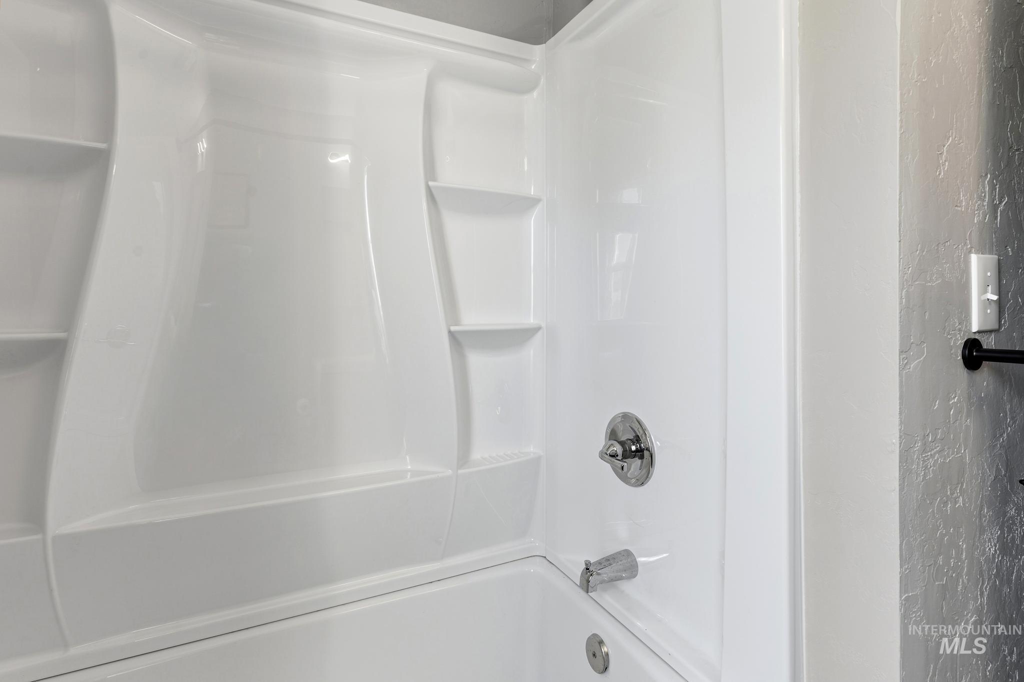 619 Thain Road Lewiston, ID 83501 - Photo 16 of 44 White fiberglass tub and shower combination featuring integrated shelving