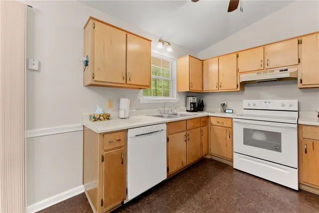 a kitchen with cabinets appliances a sink and a window
