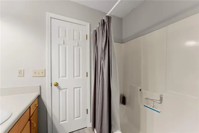 a bathroom with a shower and a sink