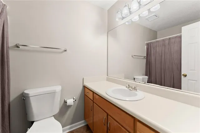 a bathroom with a sink toilet vanity and shower